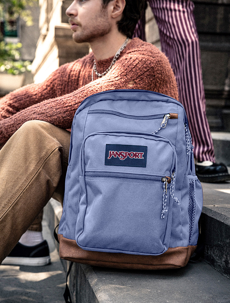 A JanSport cool student bag in Lavender on some school steps