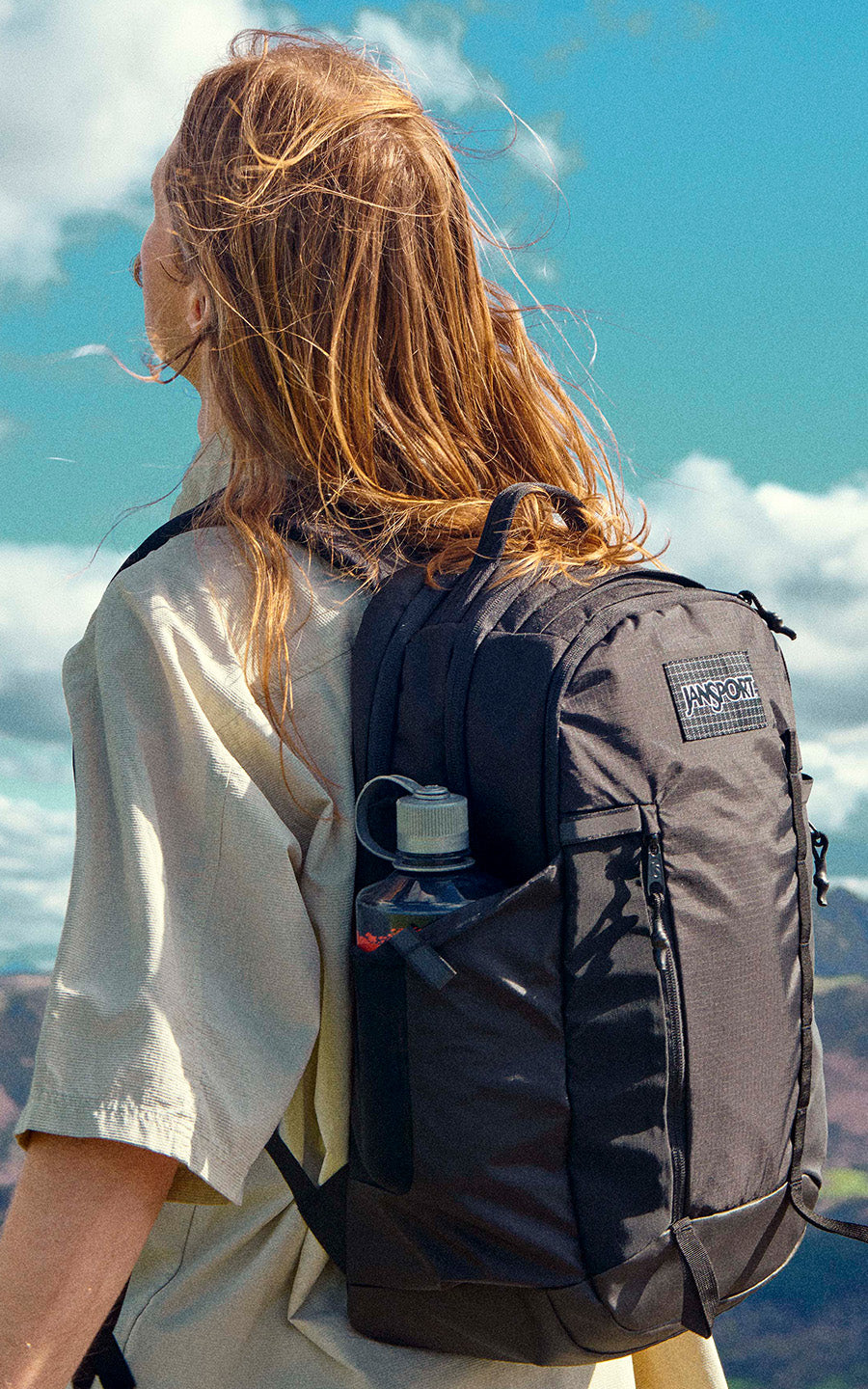 Person with a backpack against a scenic mountain backdrop